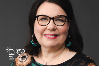 Kasvokuvassa hymyilevä tummatukkainen keski-ikäinen nainen tummasankaisissa silmälaisessa,